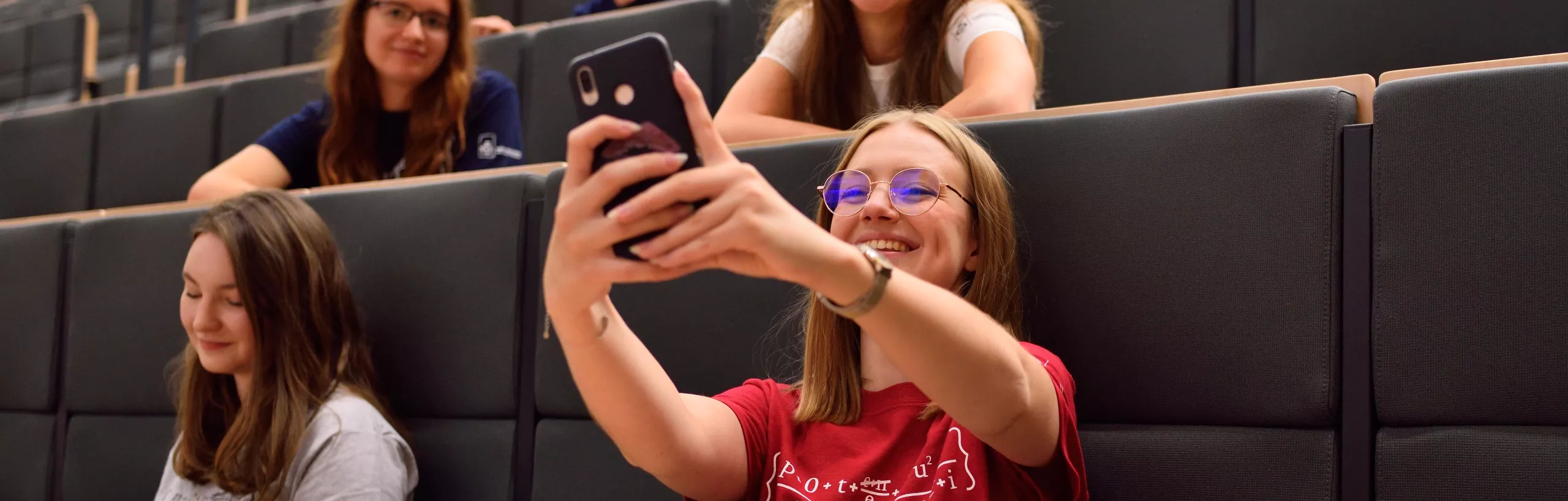 Studentka robi zdjęcie podczas wykładu.