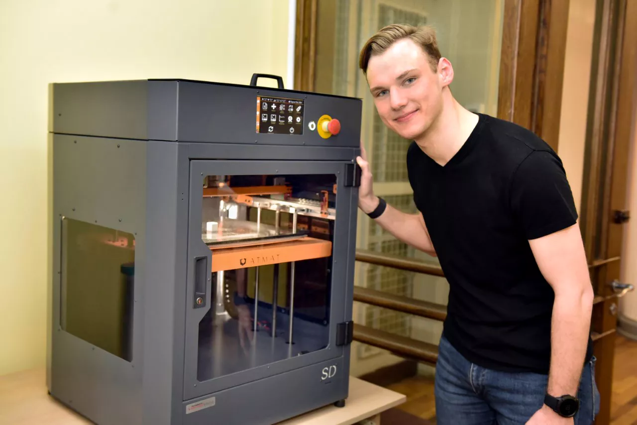 Mężczyzna stoi przy urządzeniu w laboratorium. 