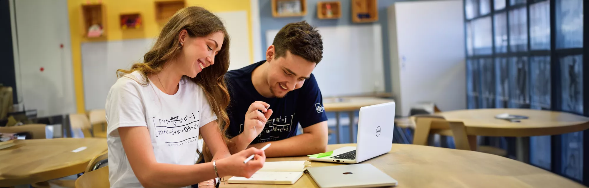 Two students sitting at a table and talking. 