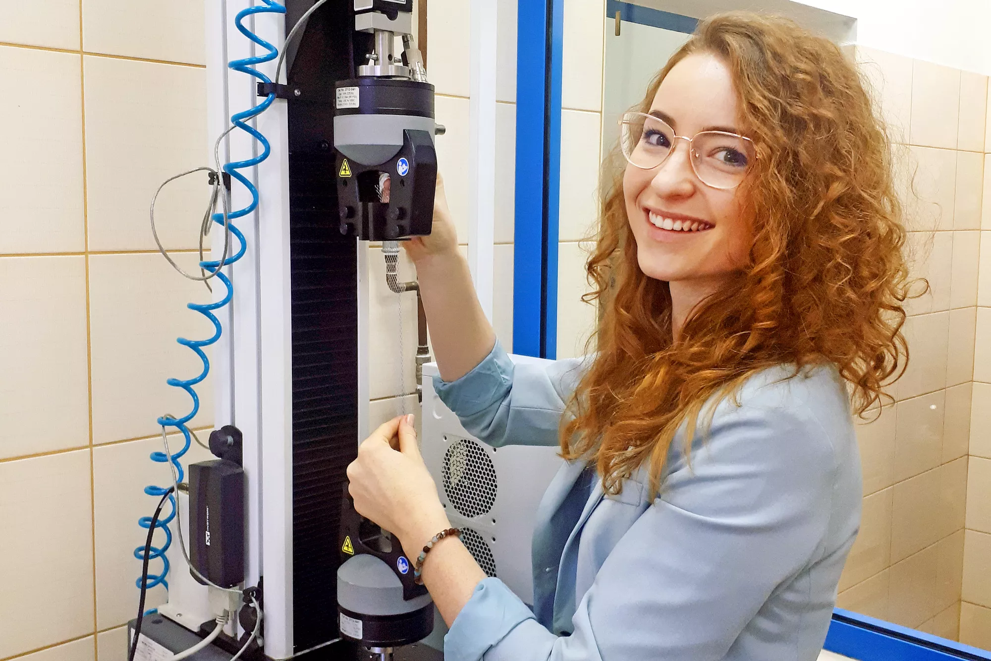 Kobieta stoi przy urządzeniu w laboratorium. 