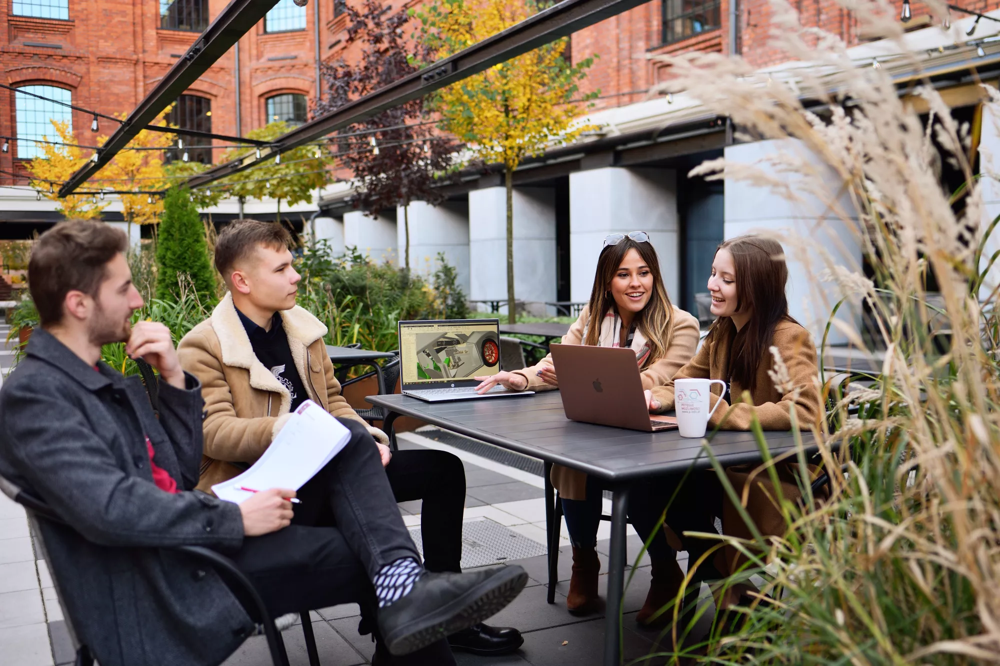 Students sitting at a table and talking. 