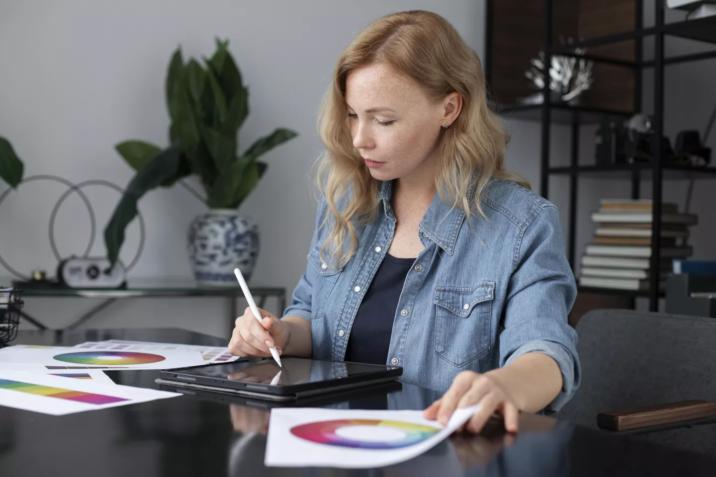 Kobieta w biurze projektująca na laptopie.