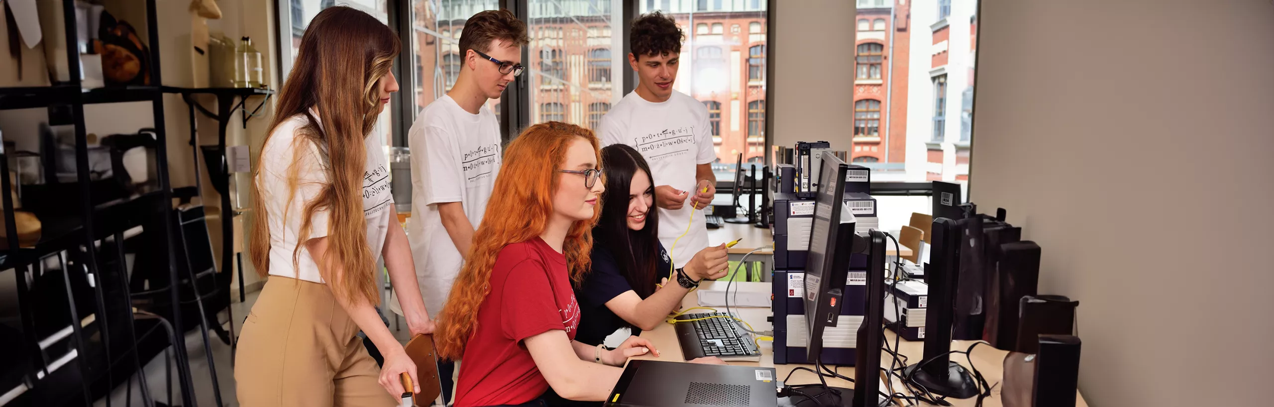 A group of students working on a computer in a classroom. 