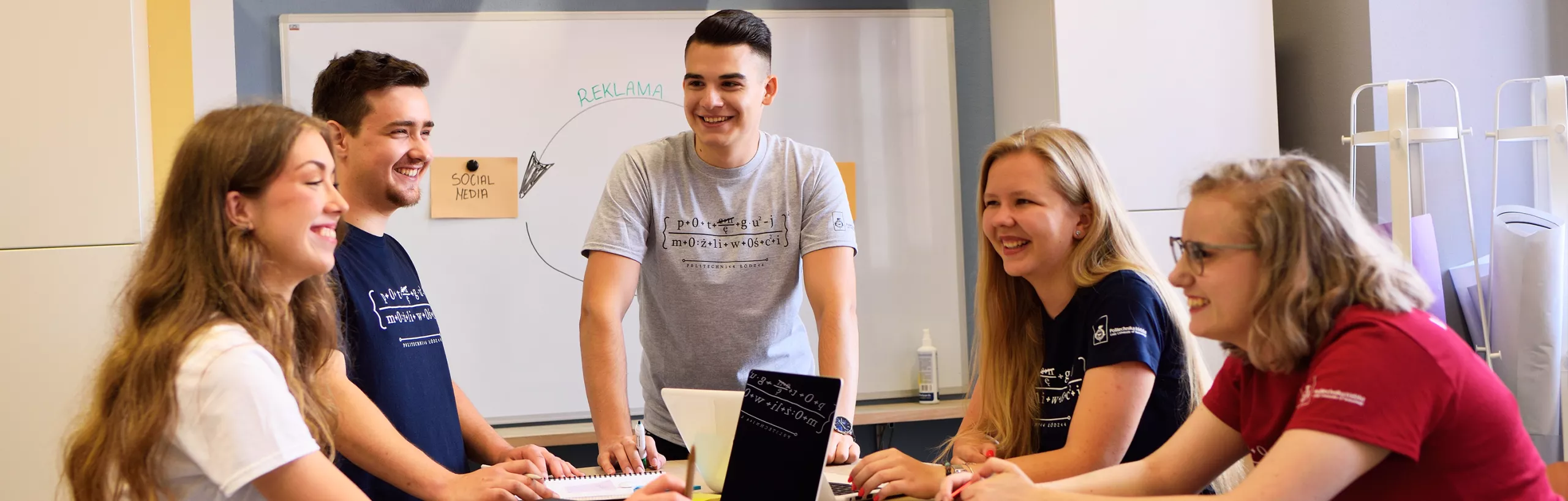 Studenci rozmawiają w sali zajęciowej.