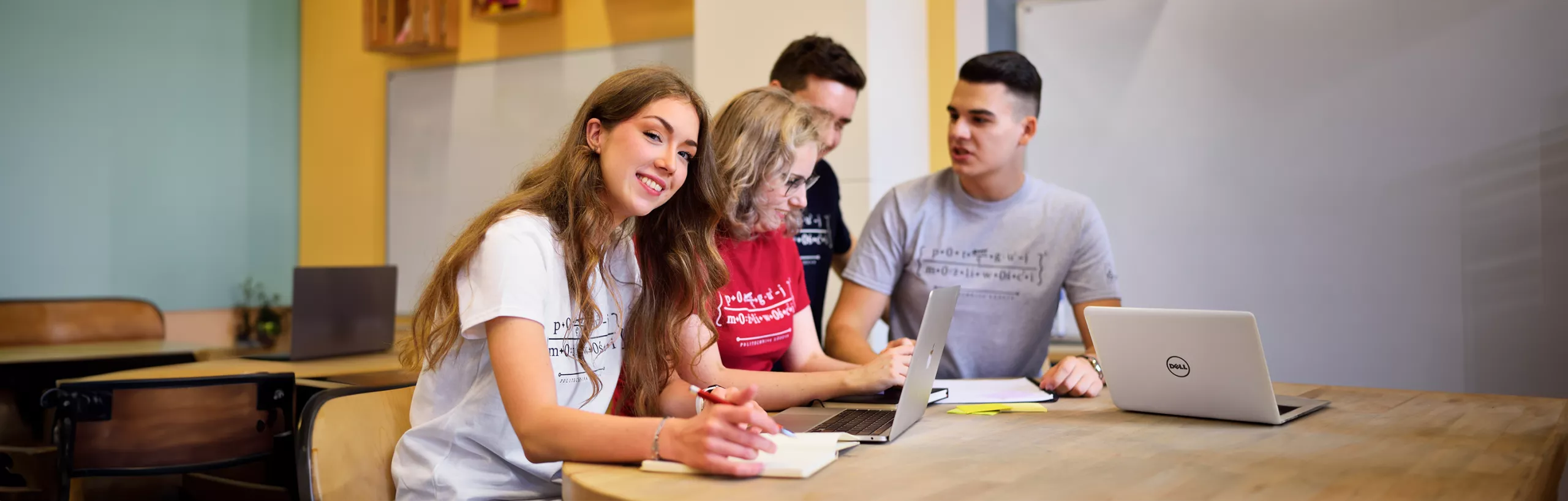 A group of students sitting at a table and talking. 